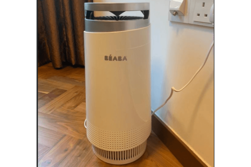 Der BEABA Luftreiniger steht auf dem Boden vor einer Wand